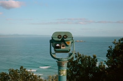 Green coin-operated binoculars in the ocean
